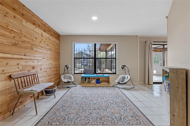 playroom featuring light tile patterned floors, wooden walls, and plenty of natural light