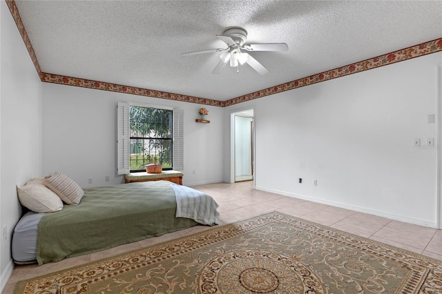 bedroom featuring ceiling fan, light tile patterned floors, and a textured ceiling