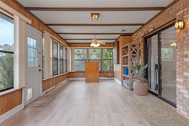 unfurnished sunroom featuring ceiling fan and beam ceiling