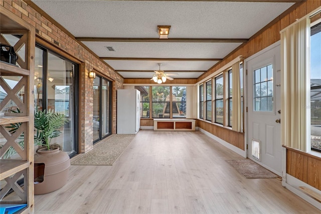 unfurnished sunroom featuring beamed ceiling