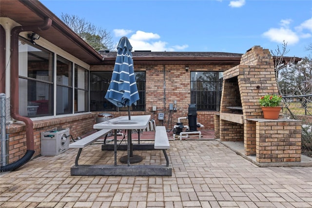 view of patio with a brick fireplace