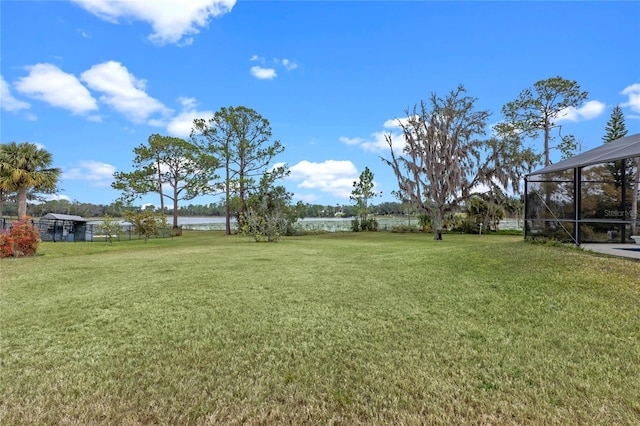 view of yard featuring a lanai and a water view