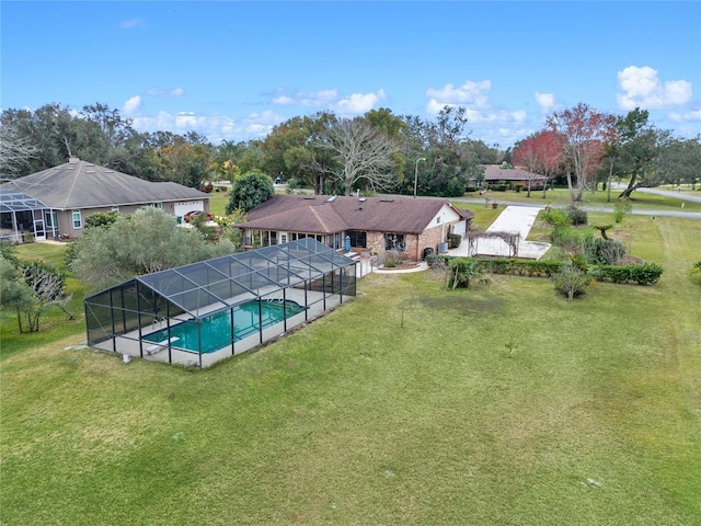 view of swimming pool with a lanai and a lawn