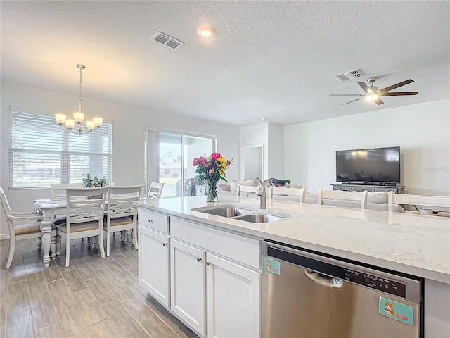 kitchen with sink, white cabinetry, a textured ceiling, decorative light fixtures, and stainless steel dishwasher