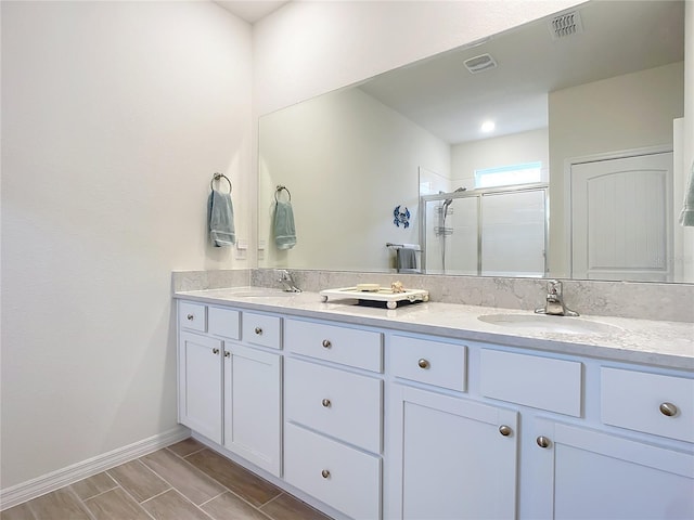 bathroom with a shower with door and vanity