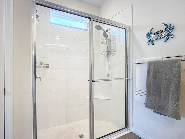 bathroom featuring a shower with shower door