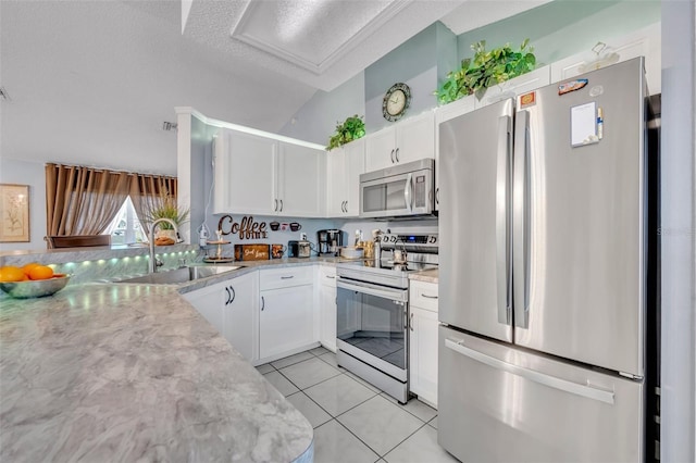 kitchen with white cabinetry, sink, stainless steel appliances, and light stone countertops