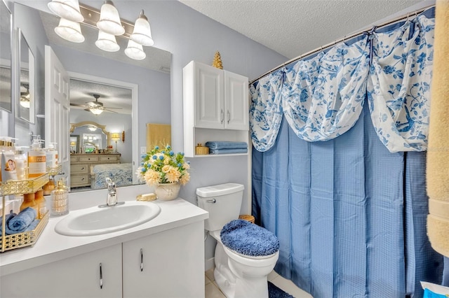 bathroom featuring ceiling fan, vanity, a textured ceiling, tile patterned floors, and toilet