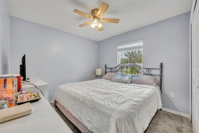 carpeted bedroom with ceiling fan and a textured ceiling