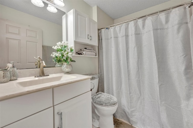 bathroom featuring vanity, toilet, and a textured ceiling