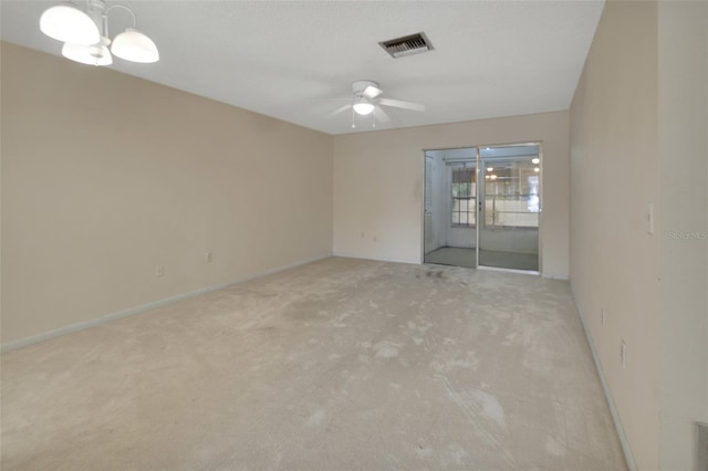 carpeted spare room featuring ceiling fan with notable chandelier and a textured ceiling