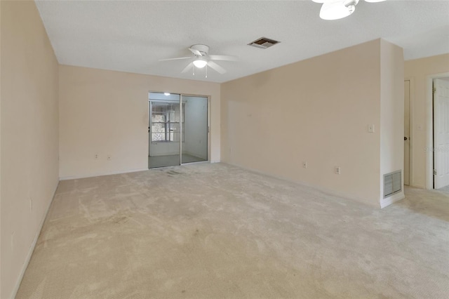 carpeted spare room with ceiling fan and a textured ceiling