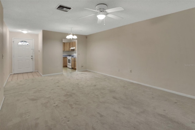 unfurnished living room featuring ceiling fan, light colored carpet, and a textured ceiling