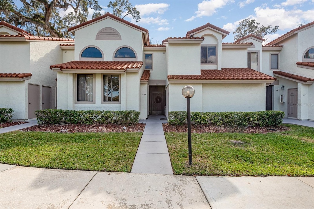 mediterranean / spanish-style home featuring a front yard