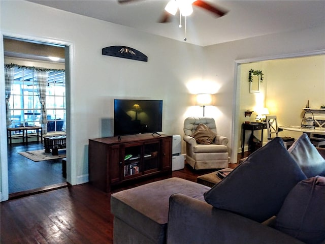 living room with dark wood-type flooring and ceiling fan