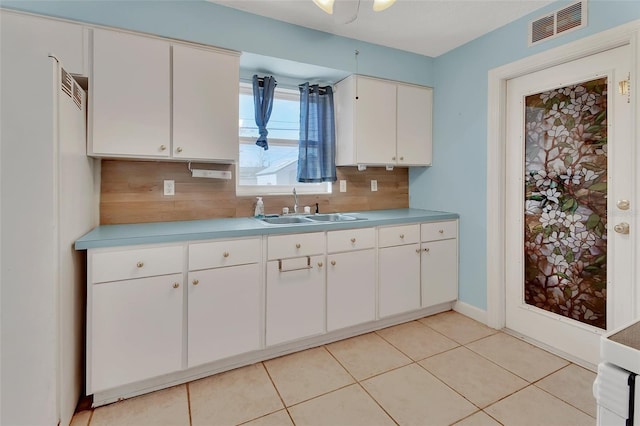 kitchen featuring white cabinetry, sink, light tile patterned floors, and decorative backsplash