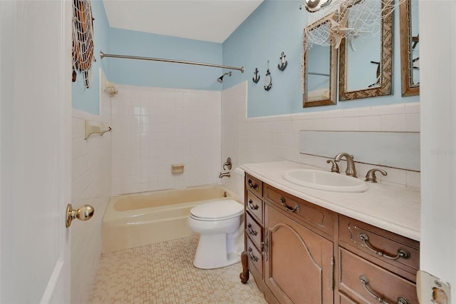 full bathroom with shower / washtub combination, tile walls, vanity, and toilet