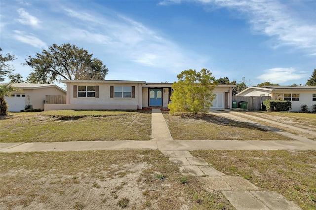 single story home with a garage and a front lawn