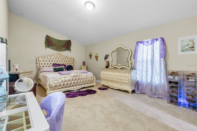 bedroom featuring vaulted ceiling, a textured ceiling, and carpet flooring