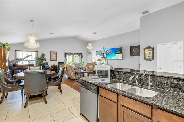 kitchen featuring sink, decorative light fixtures, stainless steel dishwasher, and dark stone counters