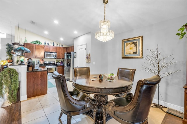 tiled dining room with lofted ceiling and a chandelier