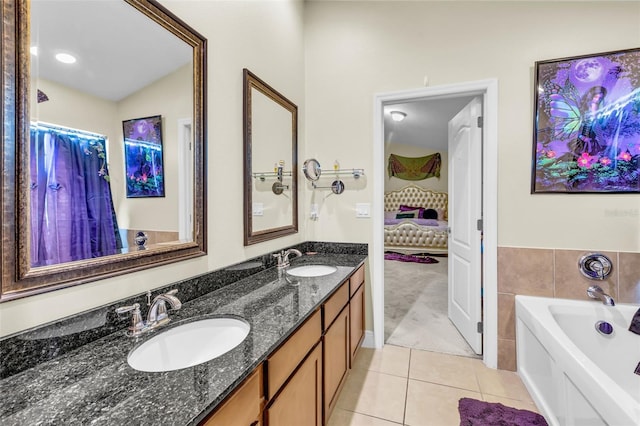 bathroom with tile patterned flooring, vanity, tile walls, and a bathing tub