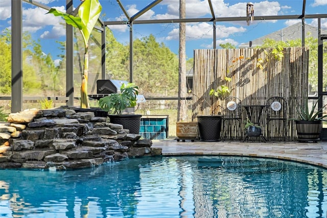 view of swimming pool with pool water feature, a patio, and glass enclosure