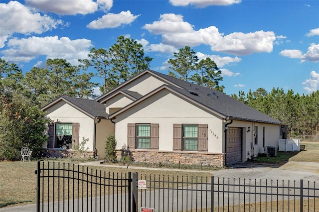 view of front of house featuring a garage, central AC, and a front lawn