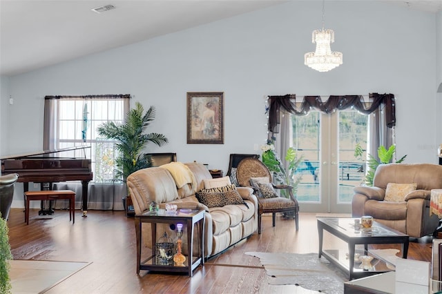 living room featuring a notable chandelier, wood-type flooring, high vaulted ceiling, and french doors