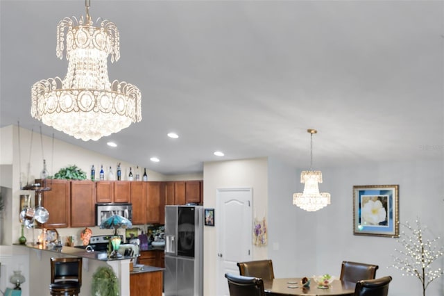 kitchen featuring stainless steel appliances, kitchen peninsula, hanging light fixtures, and a notable chandelier