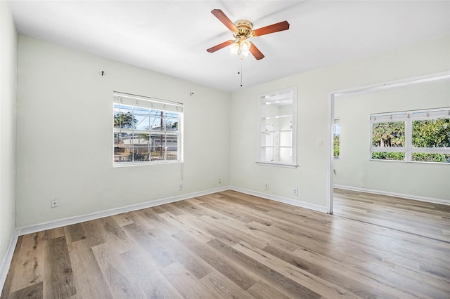 empty room with ceiling fan and light hardwood / wood-style flooring