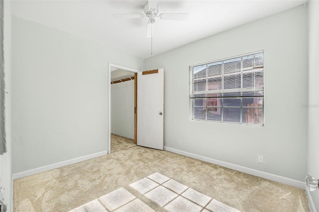 unfurnished bedroom featuring multiple windows, ceiling fan, light carpet, and a closet