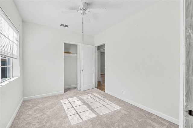 unfurnished bedroom with ceiling fan, a closet, and light carpet