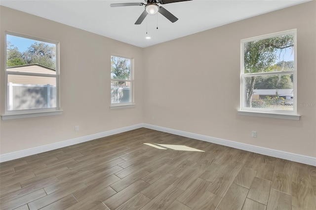 empty room with ceiling fan and light hardwood / wood-style floors