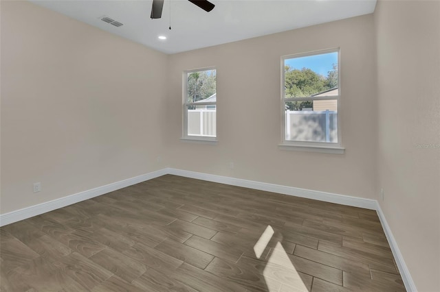 spare room with ceiling fan, plenty of natural light, and hardwood / wood-style floors