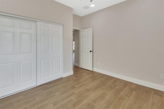 unfurnished bedroom featuring light hardwood / wood-style floors and a closet