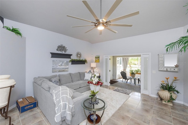 living room with lofted ceiling, ceiling fan, and light tile patterned flooring