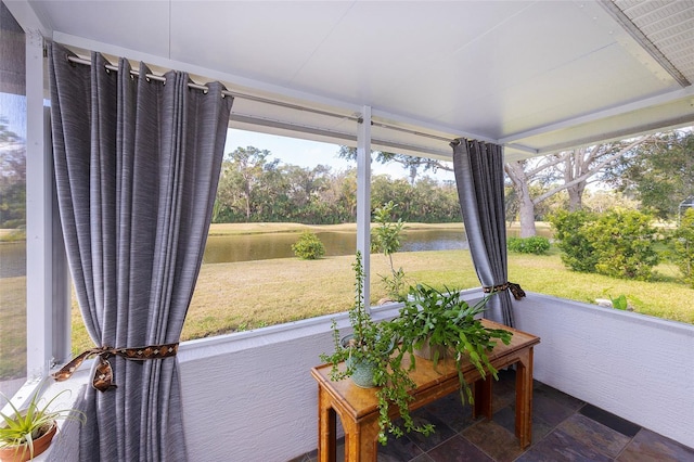 sunroom featuring a water view