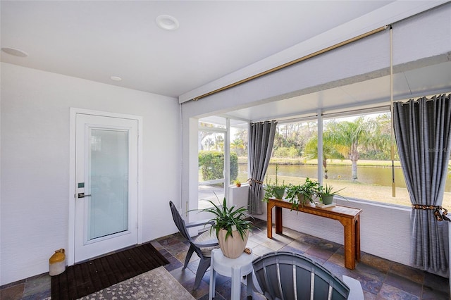 sunroom / solarium with a water view