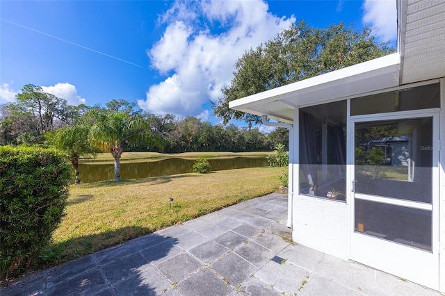 view of patio with a water view and a sunroom