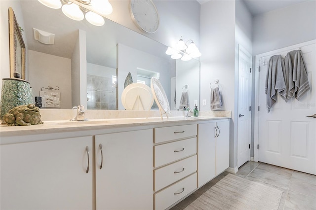 bathroom featuring an inviting chandelier, tile patterned flooring, a tile shower, and vanity