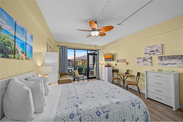 bedroom with ceiling fan, baseboards, wood finished floors, and access to exterior