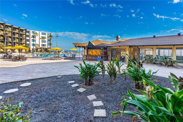 view of property's community with a swimming pool, a patio, and fence