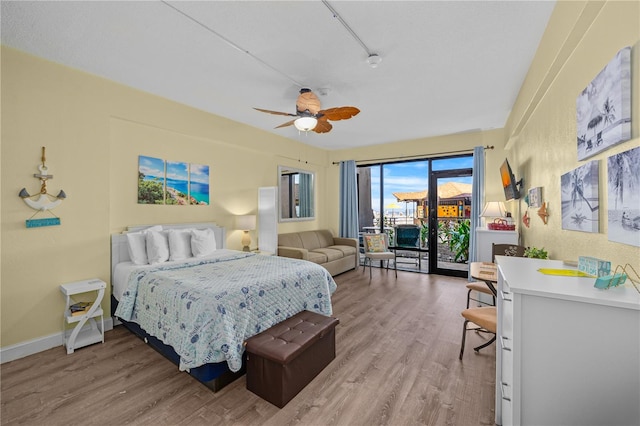 bedroom featuring ceiling fan, baseboards, light wood-style floors, and access to exterior