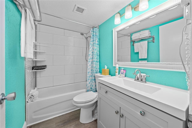 full bath featuring visible vents, toilet, wood finished floors, shower / bath combination with curtain, and a textured ceiling