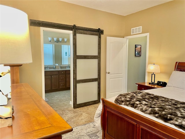 bedroom with a barn door and ensuite bath