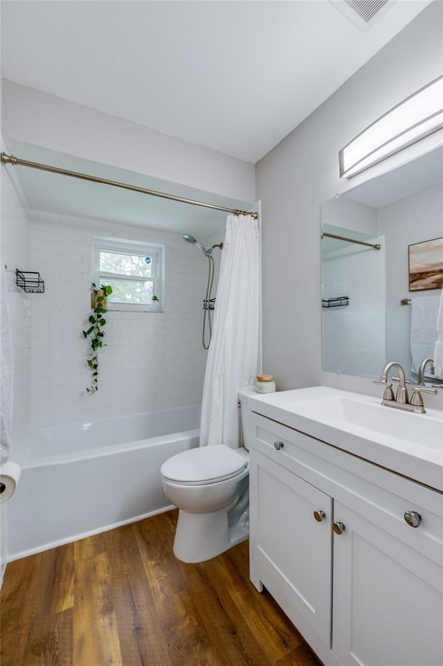 full bathroom with vanity, hardwood / wood-style flooring, shower / bath combination with curtain, and toilet