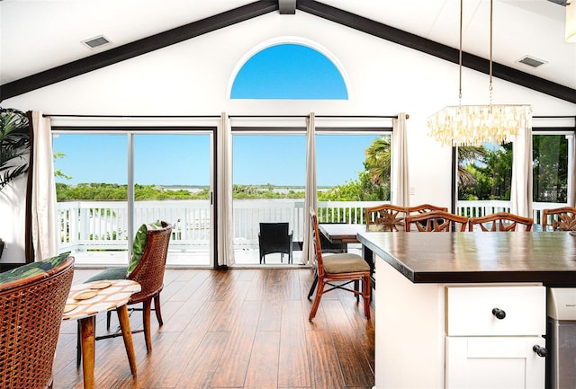 sunroom with a chandelier and vaulted ceiling with beams