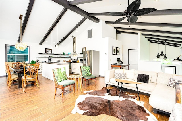 living room featuring sink, high vaulted ceiling, light wood-type flooring, beam ceiling, and ceiling fan with notable chandelier