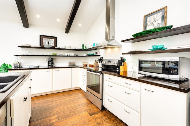 kitchen featuring extractor fan, appliances with stainless steel finishes, vaulted ceiling with beams, white cabinets, and light hardwood / wood-style flooring